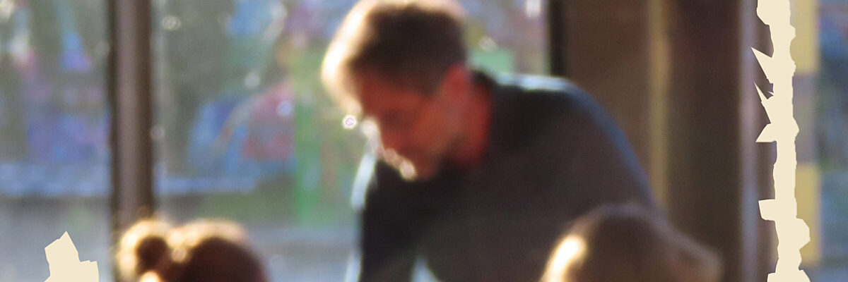 Onscherpe foto van mensen die in een zonverlicht café samen eten en drinken.
